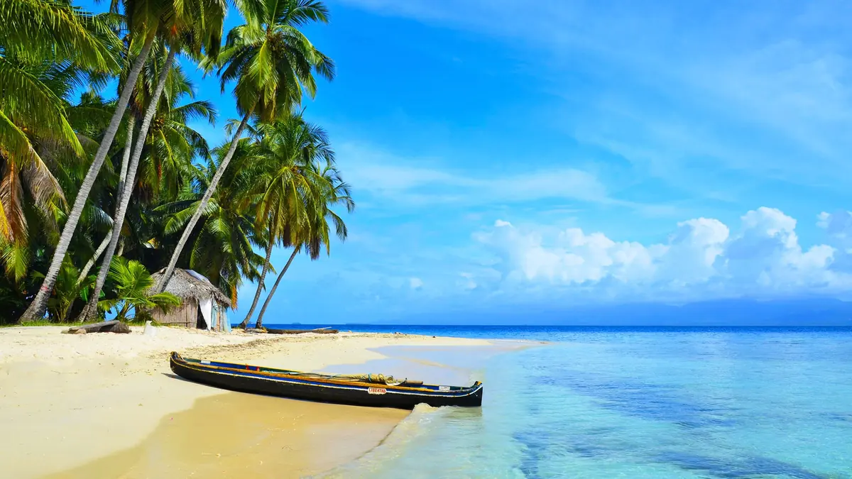 Playa de arena blanca y cayuco en las islas de San Blas, Guna Yala, Panamá